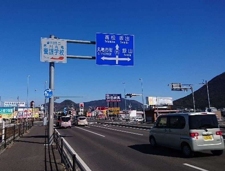 丸亀大橋を渡り、2個目の交差点（飯野交差点）を丸亀市街に向かって左折します。